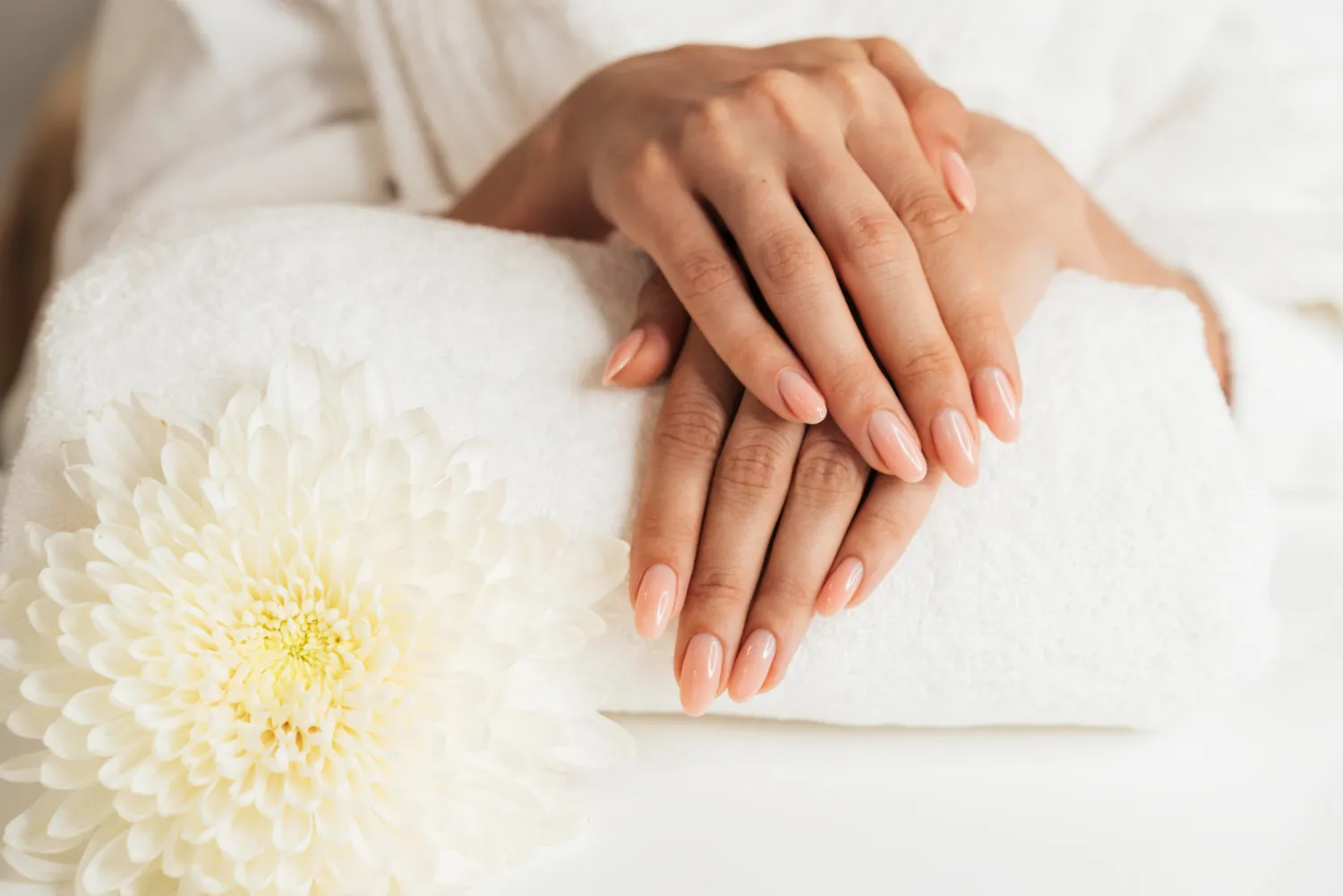 Gepflegte Hände nach der Maniküre auf weißem Handtuch – Maniküre Berlin bei Nailounge 101